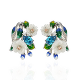 A pair of silver earrings with blue stones, enamel, shell flowers and a bird charm.
