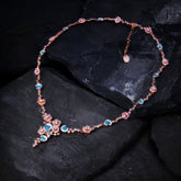 A pink gold plated necklace with enamel, pearls and shell flowers.