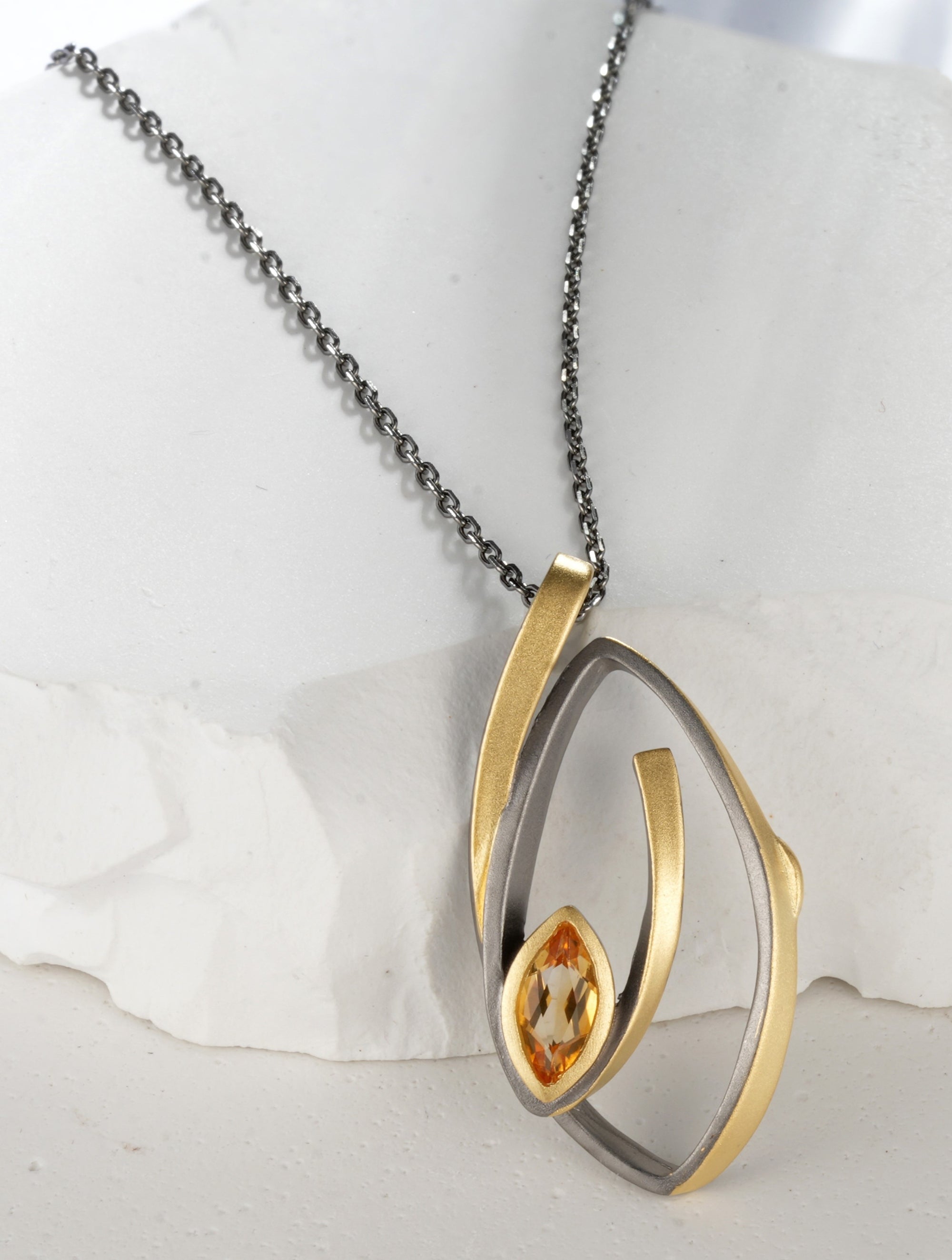 A silver necklace, gold plated with a yellow citrine stone.