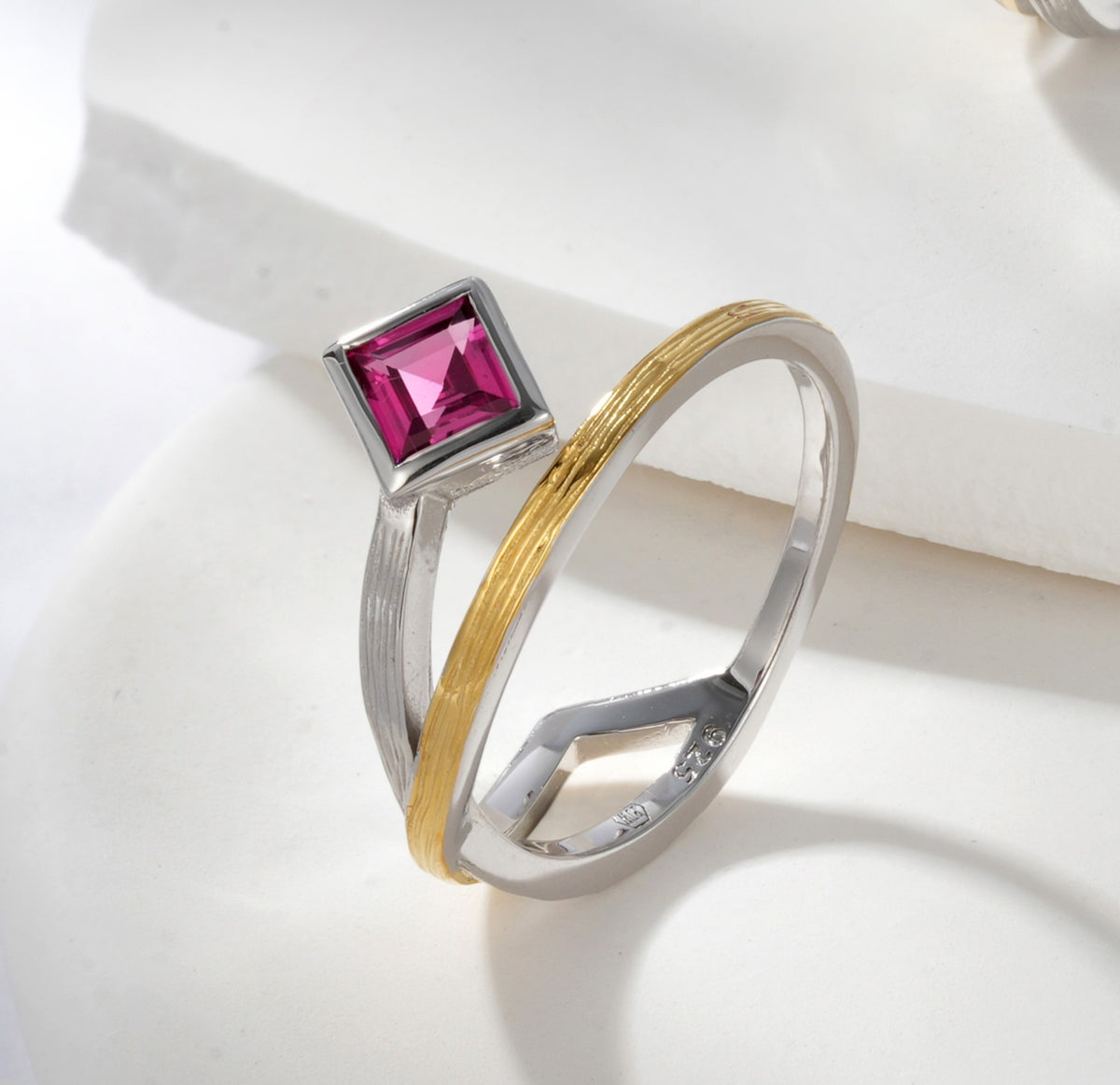 A gold and silver ring with a rodolite stone.