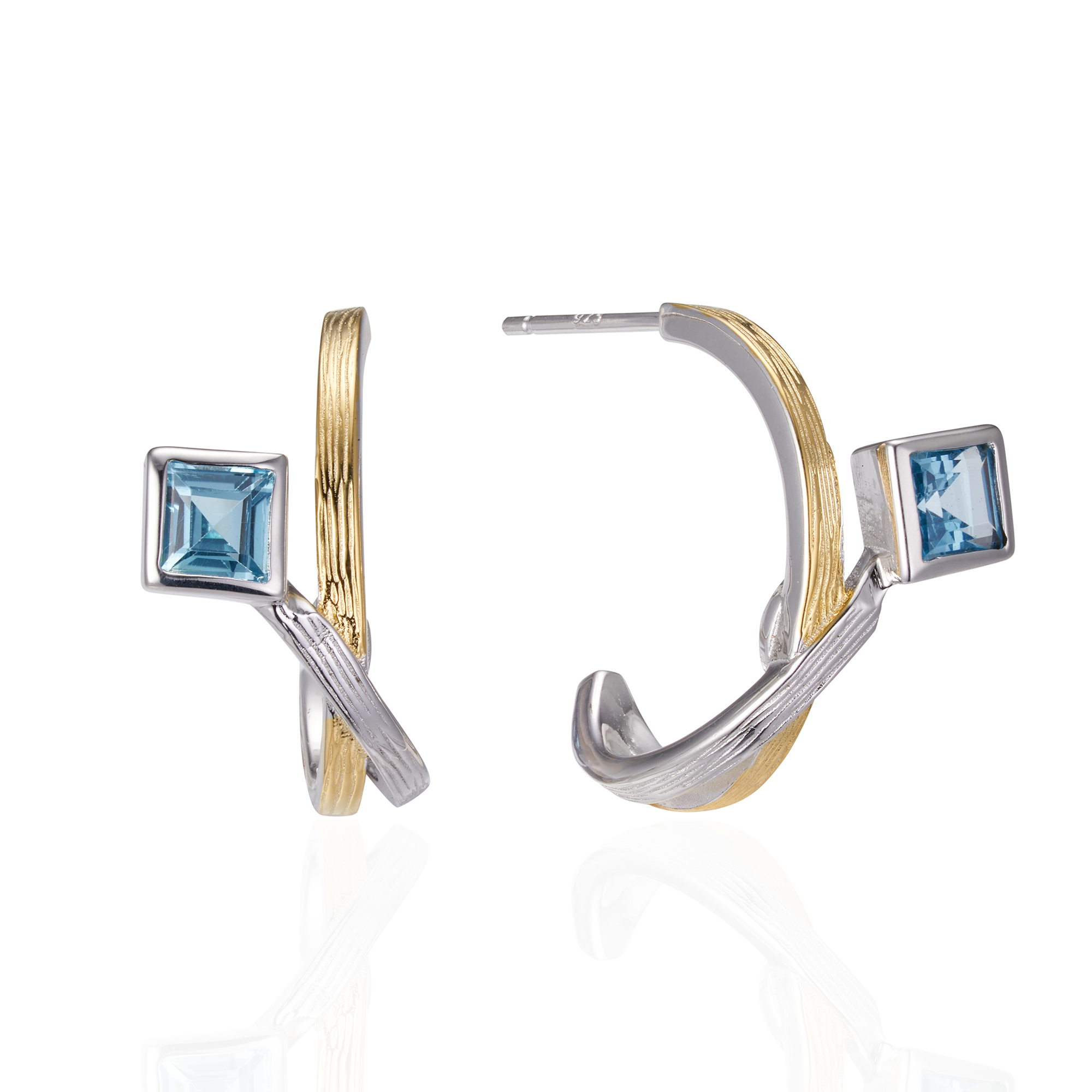 A pair of  silver earrings gold plated with square blue topaz stones.