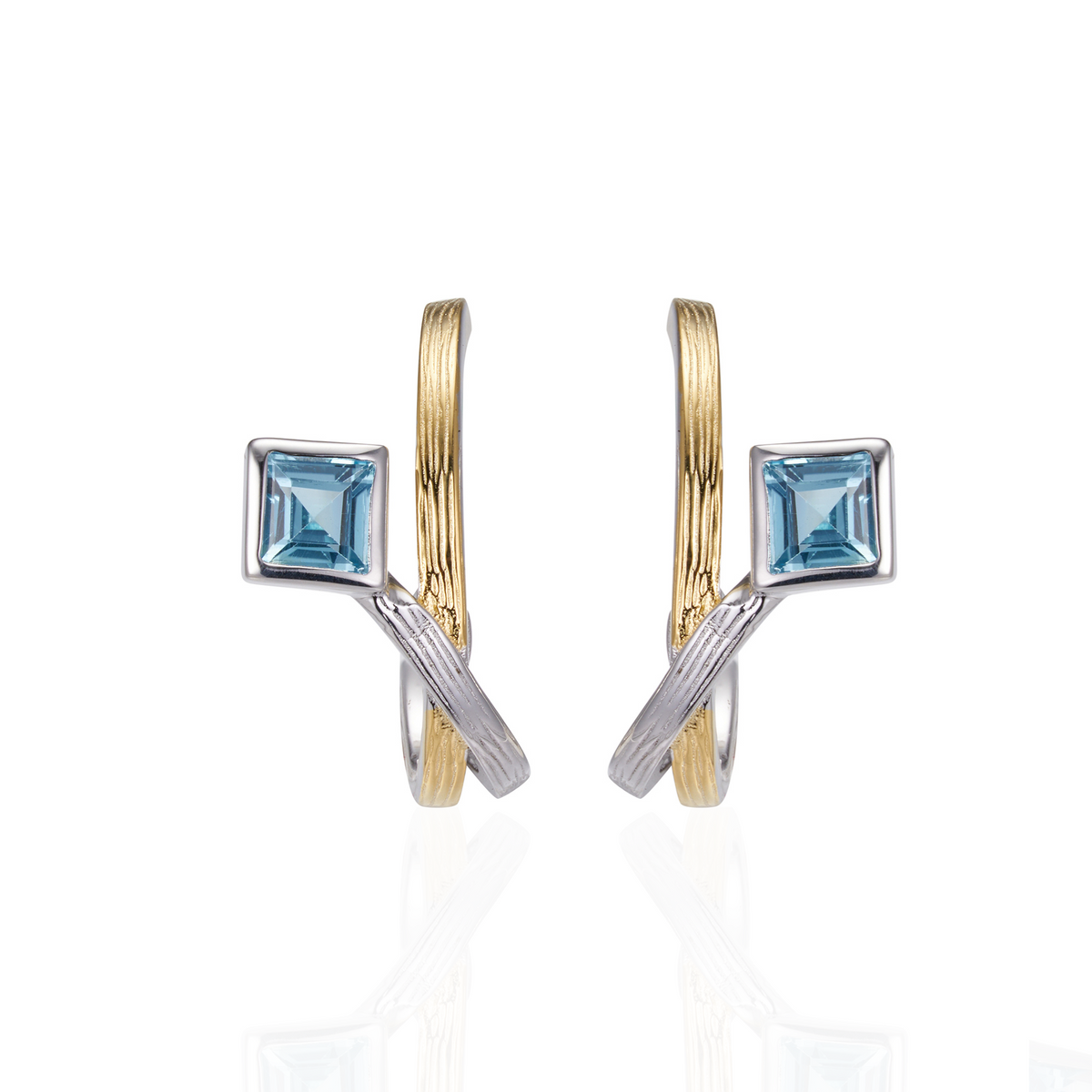 A pair of silver earrings gold plated with square blue topaz stones.